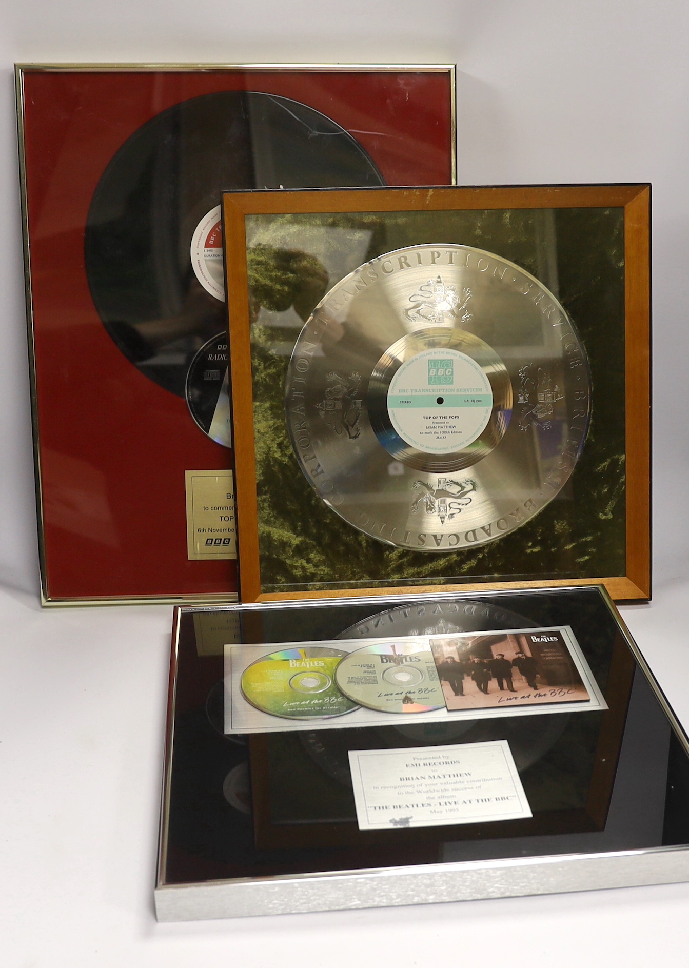 Three framed BBC related presentations to the BBC DJ Brian Matthew; ‘The Beatles - Live at the BBC’, presented by EMI Records, Top of the Pops presented to mark the 1000th edition (28.11.83), Top of the Pops, presented t